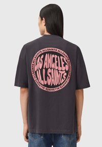 Czarny oversize T-shirt z dużą okrągłą różową grafiką i napisem "LOS ANGELES ALLSAINTS" na plecach. Wykonany z bawełny, z krótkimi rękawami.
