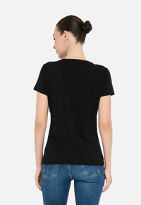 Zwarte T-shirt met korte mouwen en een klassieke ronde hals, gemaakt van zachte katoen, met een aansluitende pasvorm en een gladde textuur.