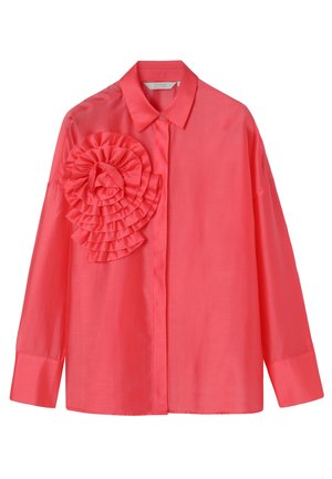 Korálová halenka s dlouhým rukávem, zapínáním na knoflíky vpředu a velkým vrstveným volánem na levé straně hrudi, s klasickým límcem a širokými manžetami.