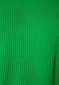 Žebrovaná zelená tkanina s měkkou texturou a svislými liniemi. Celková barva je živá a konzistentní po celé ploše materiálu.