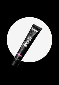 Tubetto di dentifricio nero con superficie testurizzata, caratterizzato da testo bianco e rosa. Il tappo è angolato, con uno sfondo circolare bianco che mette in risalto il prodotto.