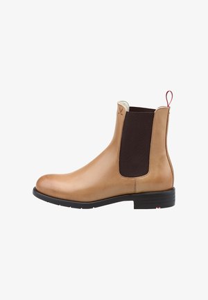 Botte Chelsea en cuir tan avec des panneaux latéraux élastiques, bout rond et une languette rouge. Dispose d'une semelle en caoutchouc noir avec une texture subtile.