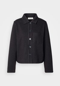 Czarna kurtka z koralikami w białe paski, z zapięciem na guziki z przodu, kołnierzem i kieszenią na piersi. Teksturowana tkanina o skróconym, lu�źnym kroju.