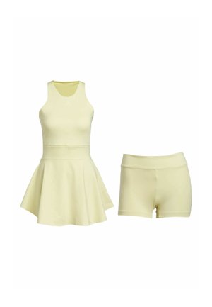 Ensemble de vêtements de sport jaune comprenant un haut sans manches avec un ourlet évasé et un short ajusté assorti, le tout en tissu léger et doux.