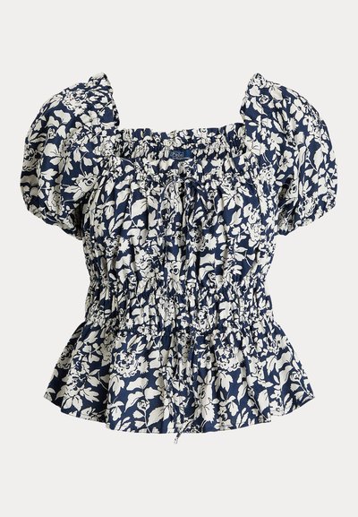 Jūras zila blūze ar baltu ziedu rakstu, pūkainām piedurknēm, smocētu jostu un regulējamu auklu. Kokvilnas sajaukums, teksturēts audums, pepluma siluets.