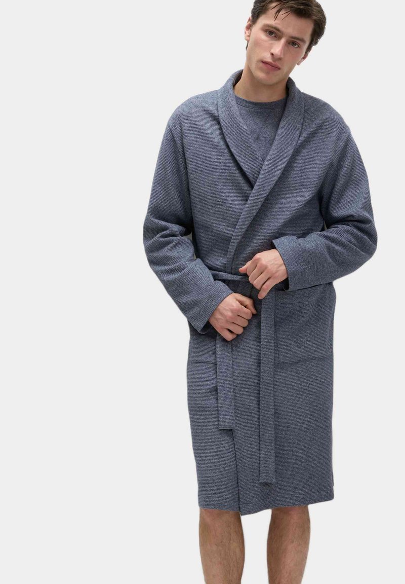 Accappatoio grigio texturizzato con colletto a scialle, chiuso con una cintura annodata. Maniche lunghe e design a lunghezza ginocchio, caratterizzato da un sottile motivo intrecciato.