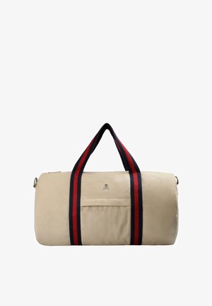 Bolsa de deporte cilíndrica beige con bolsillo delantero y dos asas a rayas negras y rojas que se extienden a lo largo de la bolsa.