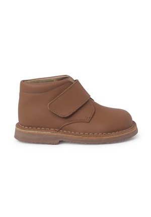 Bruine leren enkelboot met een klittenbandsluiting, ronde neus en een contrasterende gestikte zool. Gladde textuur zonder patronen.