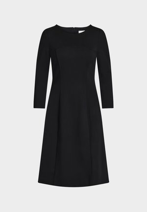 Vestido negro con escote redondo y mangas largas. Corsé ajustado con detalles de costuras y falda fluida en línea A. Cierre lateral con cremallera.