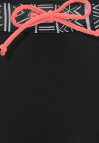 Schwarze Badeshorts mit einem gemusterten Bund in Grau und Weiß, ausgestattet mit einem leuchtend korallenfarbenen Kordelzug und metallischen Ösen.