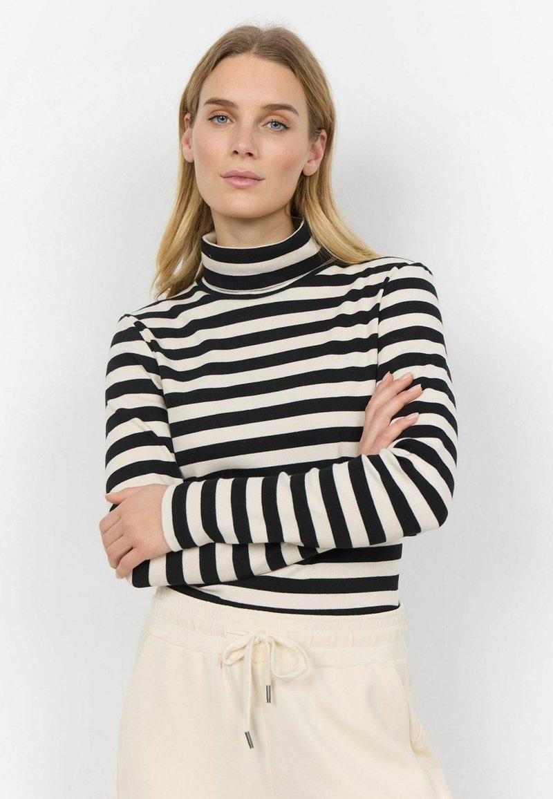 Black and cream striped turtleneck top with long sleeves, featuring a fitted design and a soft texture, paired with light beige joggers.
