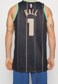 Maillot de basket-ball noir avec un col et des accents vert menthe, présentant des rayures verticales, le mot « BALL » imprimé en beige, et le numéro « 1 » en dessous.