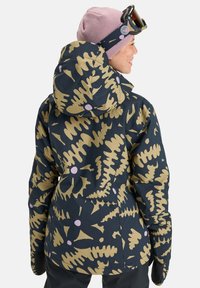 Damenjacke in Dunkelblau mit abstraktem Muster in Gold und Rosa. Merkmale sind eine Kapuze, lange Ärmel und ein taillierter Schnitt mit strukturiertem Stoff.