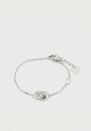 Silver chain bracelet with a small, rectangular charm encrusted with clear crystals and a triangular tag near the clasp.