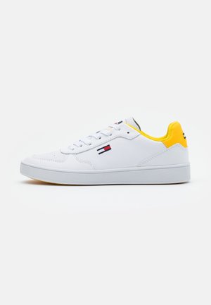 Baskets en cuir blanc avec des accents jaunes sur le talon. Dotées d'un système de laçage, d'une semelle en caoutchouc et d'un logo sur le côté. Design épuré, détails minimaux.