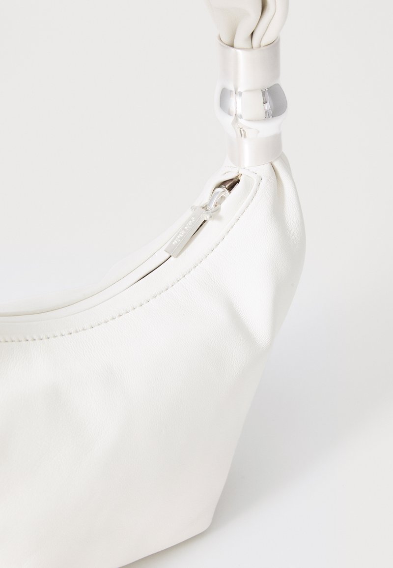 White leather handbag with silver zipper and rounded silver handle against a plain white background.