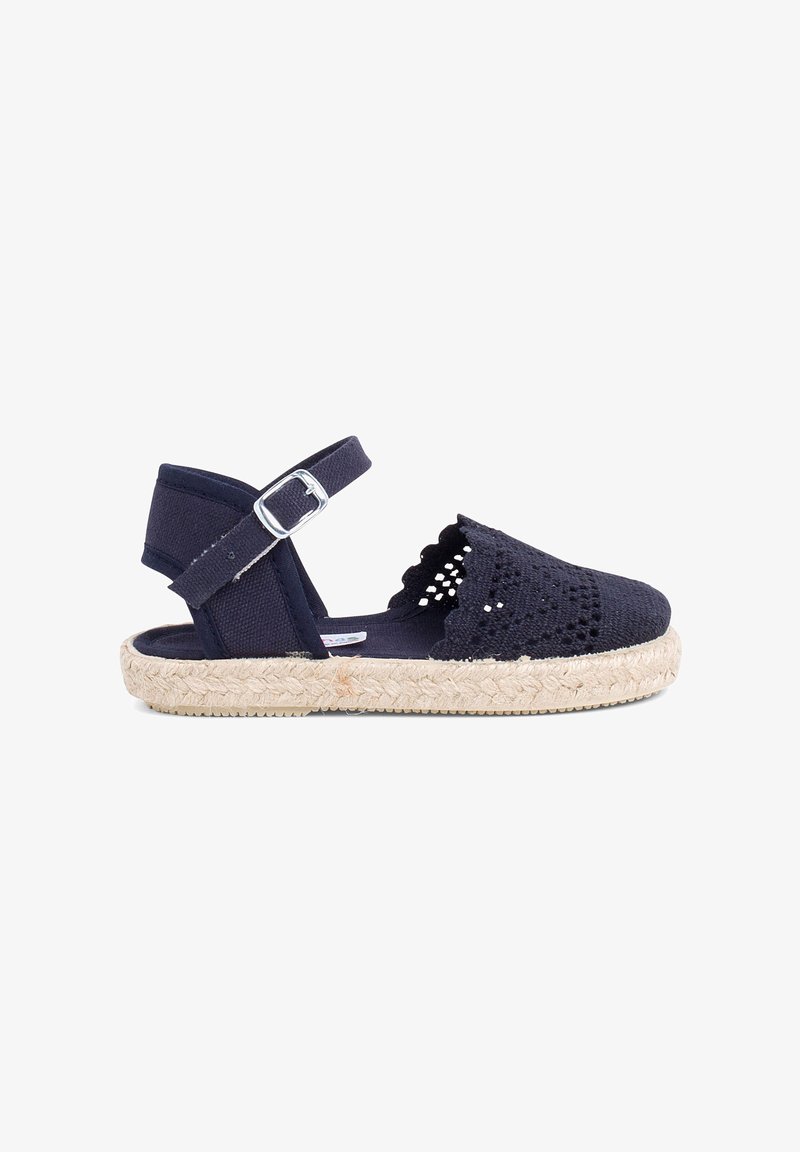 Sandale espadrille navy avec tige en tissu tissé, détail à bord ondulé, bride réglable à la cheville et semelle en jute.