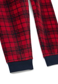 Rode en zwarte geruite fleece pyjamabroek met marineblauwe ribbelmanchetten, plat gelegd op een witte achtergrond.