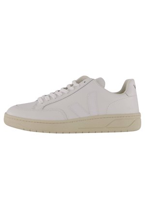 Biały niski sneaker z beżową podeszwą, sznurowanym zapięciem i subtelnym logo „V” po boku, pokazany z zewnętrznej strony na białym tle.