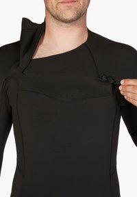 Traje de neopreno negro con cuello alto y cremallera en la parte delantera. Presenta costuras planas y una correa ajustable en el pecho para un ajuste seguro.