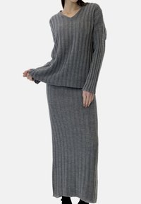 Gray ribbed knit two-piece set featuring a long-sleeve V-neck sweater and a matching full-length skirt. Soft texture with a relaxed fit.