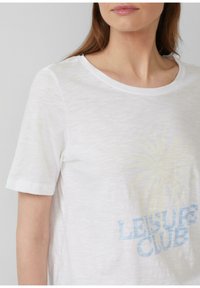 T-shirt blanc à manches courtes avec un col rond et une texture douce, ornée d'un imprimé graphique bleu pâle et jaune sur lequel est inscrit "LEISURE CLUB."