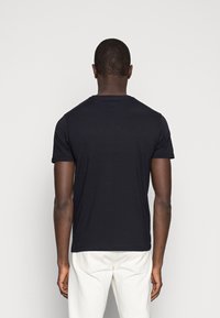 Schwarzes T-Shirt mit kurzen Ärmeln und rundem Halsausschnitt, aus glattem Stoff gefertigt, entworfen für eine taillierte Passform. Die Rückansicht zeigt saubere Nähte.