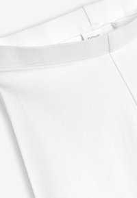 Witte katoenen top met een ronde halslijn, voorzien van een gladde textuur en nette stiksels langs de randen. Etiket zichtbaar binnenin.