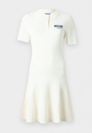 Vestito polo bianco a maniche corte con gonna a pieghe, colletto e patta con tre bottoni, con logo nero "Moschino Jeans" sul petto.