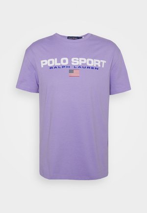 Lila Baumwoll-T-Shirt mit Rundhalsausschnitt, kurzen Ärmeln und weißem Schriftzug "POLO SPORT", dazu "RALPH LAUREN" in Blau und eine kleine amerikanische Flagge.