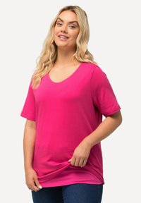Heldroze t-shirt met korte mouwen en een V-halsontwerp, gemaakt van zacht materiaal. Heeft een relaxte pasvorm en een subtiele textuur.