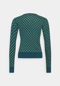 Skarpetka w kolorze teal z długimi rękawami, posiadająca teksturowany ściągacz na dole i na mankietach, z geometrycznym wzorem w odcieniach zieleni i złota.