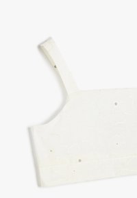 Top corto blanco con flores, con diseños bordados, tirantes ajustables y una textura suave. Presenta pequeños acentos metálicos y una forma ajustada.
