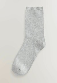 Gray sock made of knitted fabric. Features a ribbed cuff, smooth texture, and rounded toe. Simple design, no patterns or accents.