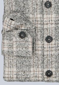 Grau-creme kariertes, strukturiertes Jackett mit schwarzen Knöpfen. Verfügt über eine Vordertasche mit Knopfverschluss. Das Material wirkt gewebt und robust.