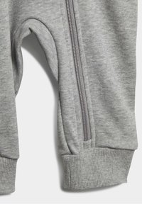 Grijze sweatpants met rits, voorzien van een zachte textuur, ribbelmanchetten en een zijritsdetail nabij de knie voor flexibiliteit en draaggemak.