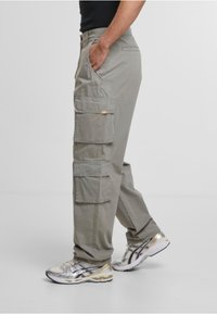 Pantalons cargo gris clair avec de multiples poches latérales et une coupe décontractée. Fabriqués en tissu mélangé de coton, avec une étiquette sur la poche droite.