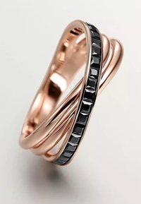Anillo de oro rosa con bandas entrelazadas; presenta un acento de piedra negra facetada a lo largo de un lado, resaltando un diseño elegante y moderno.
