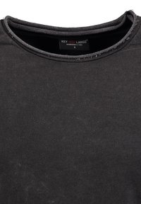 Zwart katoenen T-shirt met ronde halslijn, voorzien van een vervaagde textuur en zichtbare stikselaccenten. Etiket leest "KEY LARGO, maat S."