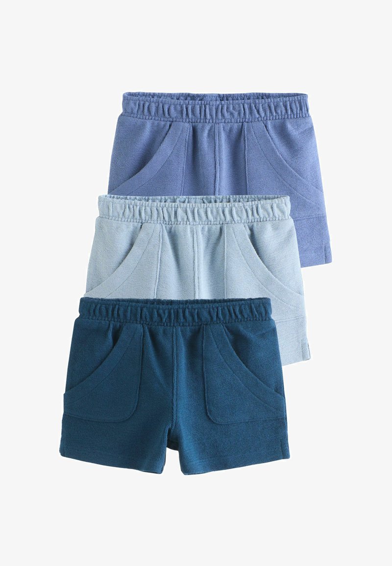 Trois paires de shorts enfant à taille élastique en bleu, bleu clair et bleu marine, empilées verticalement avec les poches avant visibles.