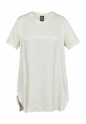 Kurzärmliges, V-Ausschnitt-Oberteil aus leicht beigem Stoff mit subtiler vertikaler Streifenstruktur und seitlichen Schlitzen für mehr Bewegungsfreiheit.