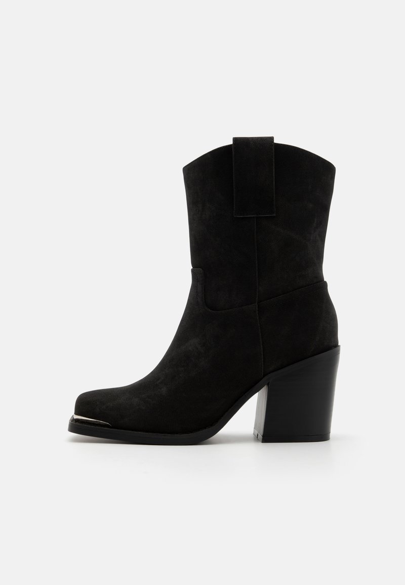 Bottines en suede noir, à bout carré, avec un haut talon bloc et une languette à l'arrière. Texture lisse avec un design simple et sans matériel supplémentaire.