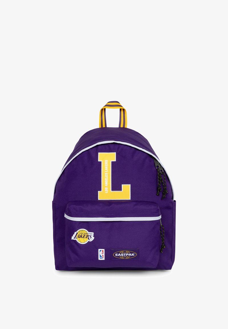 Mochila de tela morada con un gran logo amarillo en forma de "L", detalles en blanco en las cremalleras y logos de la NBA y Eastpak en el bolsillo delantero.