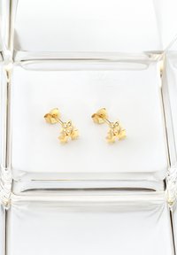 Goldene sternförmige Ohrringe mit silbernen Akzenten, die eine glatte Textur und kleine dekorative Steine aufweisen. Mit einem Butterfly-Verschluss montiert.
