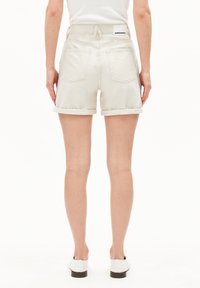 Witte denim shorts met opgerolde boorden, achterzakken en een label op de tailleband. Gladde textuur, casual ontwerp en een mid-rise pasvorm.