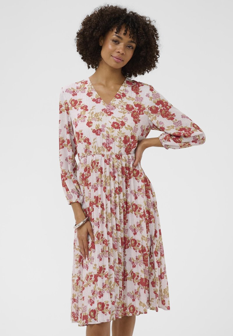 Vestito floreale con scollo a V, maniche lunghe a palloncino, sfondo rosa pastello e motivi floreali rossi, rosa e dorati. Design di lunghezza media.