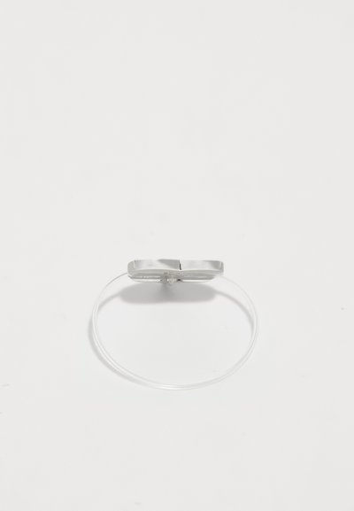 Silberring mit flachem, rechteckigem Kopf, montiert auf einem flexiblen, klaren Band. Verfügt über ein minimalistisches Design und eine glatte Textur.