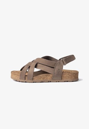 Bruine lederen sandaal met gekruiste banden, verstelbare enkelband en kurken zool op witte achtergrond.