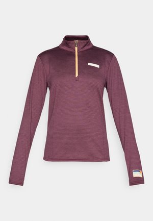 Langärmliger Pullover mit Reißverschlusskragen in tiefem Lila mit texturiertem Muster. Mit einem orangefarbenen Reißverschluss und einem kleinen Logo-Patch am linken Ärmel.