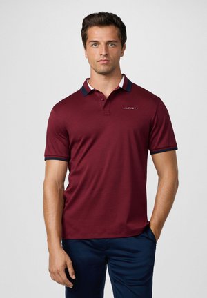 Bordeaux polo shirt van lichtgewicht stof, met een contrasterende marinekleurige kraag met rode en witte strepen, en een logo op de borst.